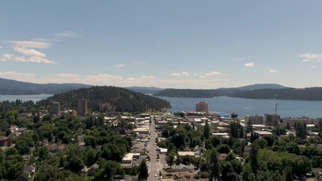 Aerial drone shot coming up fourth street in Coeur d'Alene with views of the lake, Tubbs Hill and the Resort.