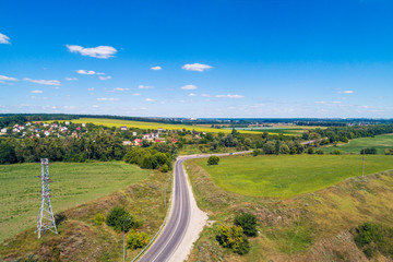 Summer rural landscape, aerial view. View of the village, green fields, and road