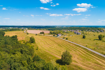 Fototapeta na wymiar Summer rural landscape, aerial view. View of the village, green fields, and road