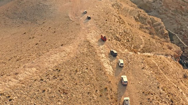 Jeeps on a off road trip in a dunes desert, 4k aerial drone view
