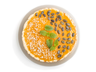 Traditional american sweet pumpkin pie decorated with mint, sesame and pumpkin seeds isolated onwhite background. top view.