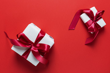 Two white gift boxes on a red background. Valentine's day. Holiday of lovers.