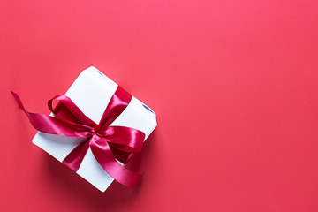 White gift box on red background. Valentine's day. Holiday of lovers.