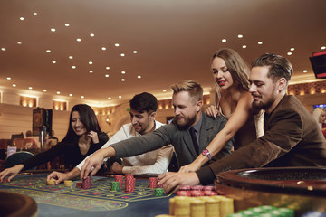 Friends gambling betting in a casino.