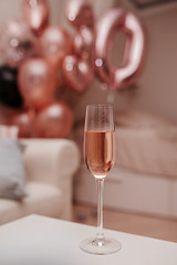 elegant glass with pink champagne against the background of fake pink balls 30