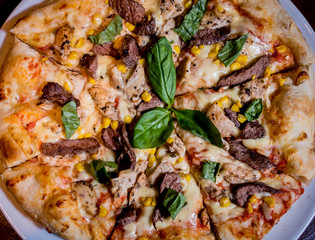 Tasty pizza with chicken and vegetables. Restaurant.