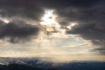 Sun rays of light on snow-capped mountain peaks