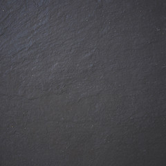 Black stone background texture. Top view on a solid embossed surface. Copy space