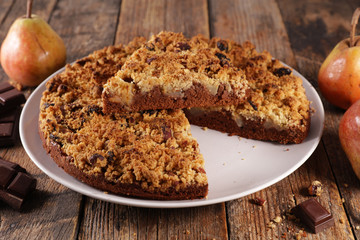 crumble with pear and chocolate on wood background