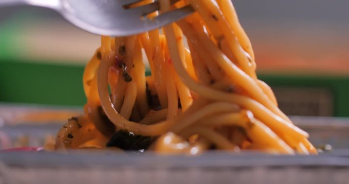 Close-up shot the fork picking hot and spicy spaghetti Italian food select focus shallow depth of field