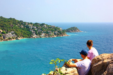 couple sitting on top of mountain in loving moment looking the beautiful landscape ,seascape view  celebrate NEW YEAR and VALENTINE.