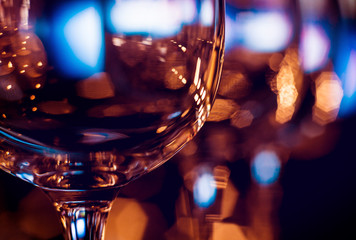 Wine and martini glasses in shelf above a bar rack in restaurant. Empty clean glasses in bar.