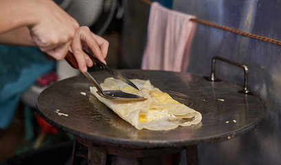 Chef prepares Thai Roti at a street food stand in Bangkok, Thailand