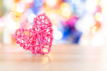 Beautiful pink wooden heart over blurred colorful bokeh background, love and romance concept, valentine day