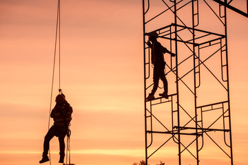 Silhouette Engineers Worker discussion with architects work planing in construction site working on high ground heavy industry and safety concept