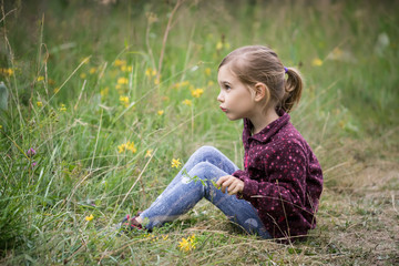 Lovely little girl playing in the summer field