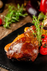 Serbian, Balkan cuisine. Lamb of leg with gnocchi. Serving in a restaurant on a black slate, on wooden table. background image, copy space