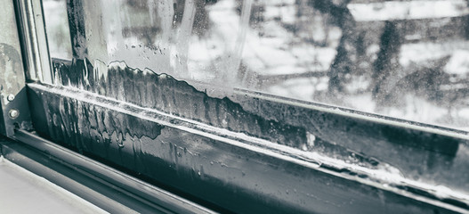 Window humidity condensation in home interior during cold winter weather panoramic background. House problem.