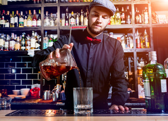Bartender is making cocktail at bar counter. Fresh cocktails. Barman at work. Restaurant. Nightlife.