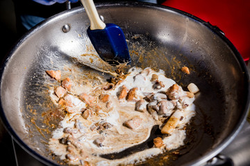 Chef cooking pasta with mussels in pan. Italian style cuisine. Restaurant.