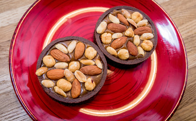 Chocolate cookies with almond nuts on a red plate. Restaurant.