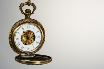 Vintage pocket watch with open cap. Antique clock, close-up macro view, isolated on gray gradient...