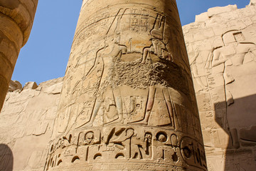 Karnak temple complex in Luxor, Egypt. Ancient bas relief with hieroglyphs and gods on column.