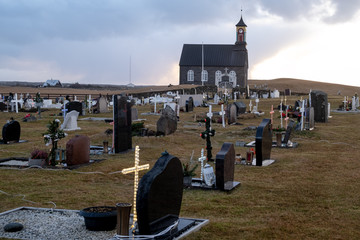 Hvalsneskirkja with the Hvalneskirkjugarður cemetery. In the dark season, between Christmas and New Year, the graves in Iceland are decorated with mostly electric lights.