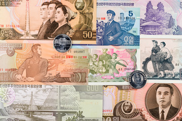 Two North Korea Won coins on a different banknotes background. DPRK money close-up macro.