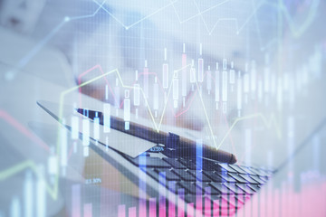 Forex graph hologram on table with computer background. Multi exposure. Concept of financial...