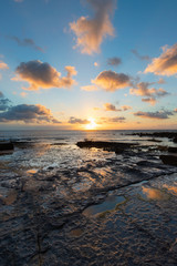 Cloudy sunrise view on the rocky coastline.