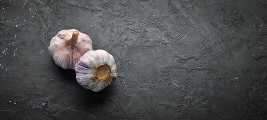 Fresh garlic on a dark background. Vegetables. Top view. Free space for your text.