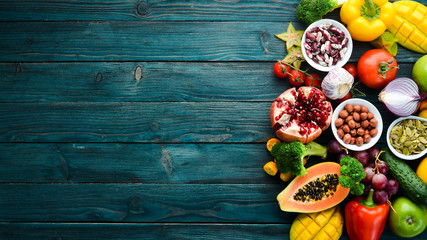 Background Organic food. Fruits, vegetables, beans and nuts on a blue background. Top view. Free space for your text.