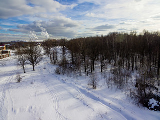 Bird's-eye view of the city and forest in snowy winter.