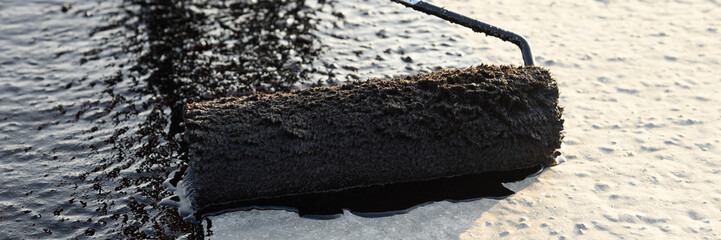 Worker applies bitumen mastic on the foundation