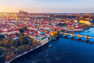Obraz premium Aerial Prague panoramic drone view of the city of Prague at the Old Town Square, Czechia. Prague Old Town pier architecture and Charles Bridge over Vltava river in Prague at sunset, Czech Republic.