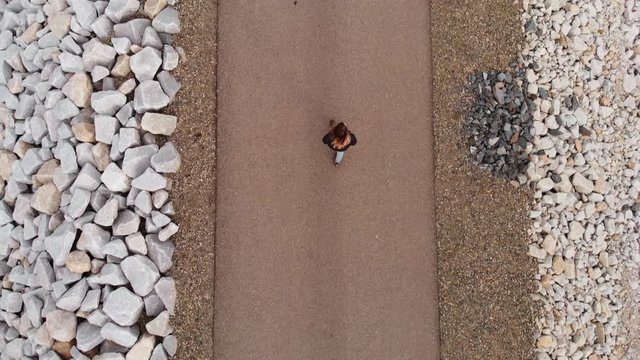 Aerial Top Down Tracking Shot of Person Walking Down Center of Road