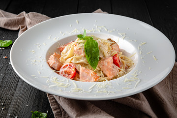 Pasta with seafood, salmon, cream sauce and cherry tomatoes.