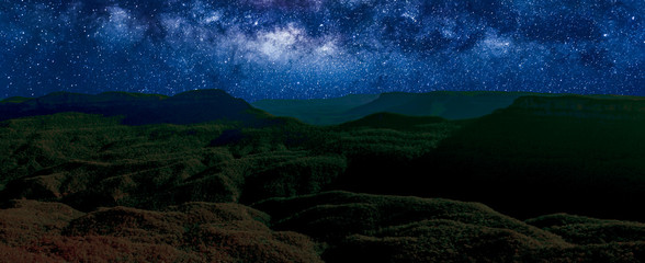 Banner panorama of Blue Mountains National Park by night with milky way, stars field and galaxies. New South Wales, Australia.