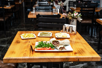 close up of kebab sandwich on wooden background