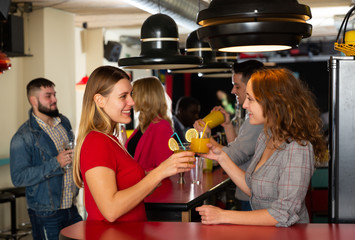 Young women drinking cocktails and talking on  party