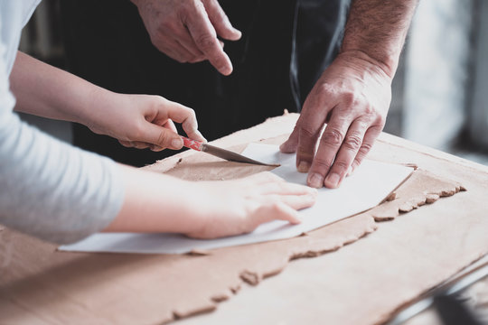 Craftsman teaching child how to cut clay for creating vase crafts hobby workshop