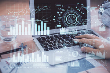 Multi exposure of market chart with man working on computer on background. Concept of financial analysis.