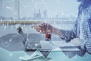 Double exposure of stock market chart with man working on computer on background. Concept of financial analysis.