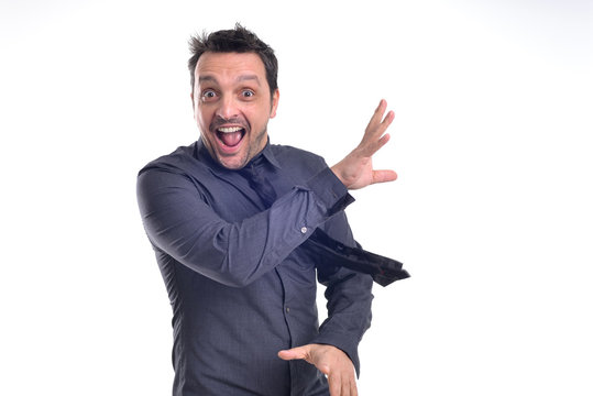Portrait of a young dude isolated on white, wearing a grey shirt and a black tie acting excited, surprised, pulling faces .