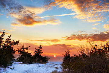 Fototapeta na wymiar Beautiful orange sunset in winter mountains with snow