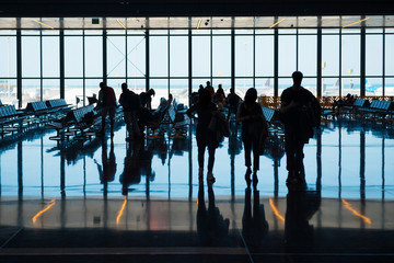 Group of silhouette people in airport go to registration with luggage 