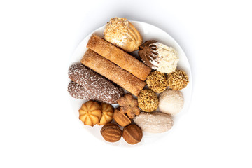 Different types of cookies on white plate isolated on white background.