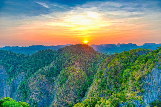 Majestic landscape with dramatic sunset and silhouette of steep mountain ridge on horizon. HDR image