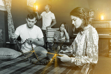 Friends looking at wooden rosary in quest room